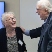 Two event attendees smiling and greeting each other